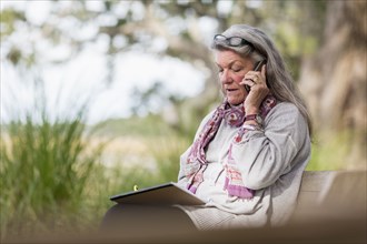 Older Caucasian woman talking on cell phone outdoors