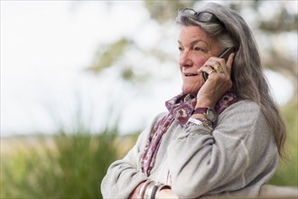 Older Caucasian woman talking on cell phone outdoors
