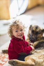 Caucasian baby boy playing with dog on floor