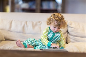 Caucasian baby boy using digital tablet on sofa