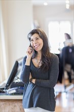 Hispanic small business owner talking on telephone