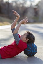 Caucasian boy playing basketball on court