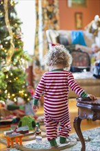 Caucasian baby boy playing with toys near Christmas tree
