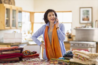 Hispanic business owner talking on telephone in home office