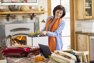 Hispanic business owner packing boxes in home office