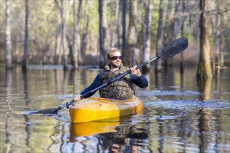 Caucasian man rowing canoe in river