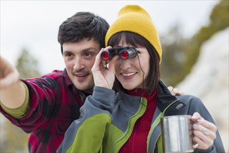Couple admiring view with binoculars