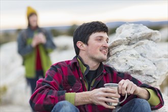 Couple drinking coffee on rock formations