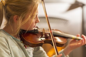 Close up of Caucasian girl practicing violin