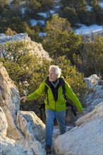 Older man climbing remote rock formations