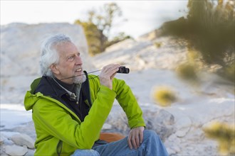 Older man admiring view with binoculars