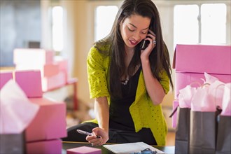 Mixed race businesswoman talking on telephone in office