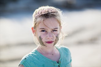 Caucasian girl with messy face on beach