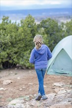 Caucasian girl standing at campsite in desert