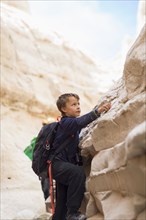 Boy climbing desert rock formations