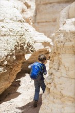 Caucasian boy exploring desert rock formations