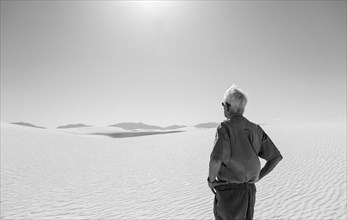 Caucasian man admiring desert sand dunes