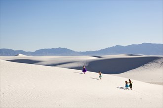 Girls walking on desert sand dunes