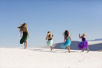 Girls walking on desert sand dunes