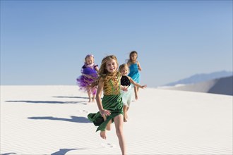 Girls running on desert sand dunes