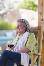 Caucasian woman drinking wine on porch
