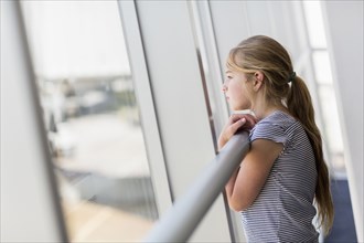 Caucasian girl looking out airport window