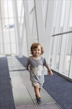 Caucasian baby boy walking in airport