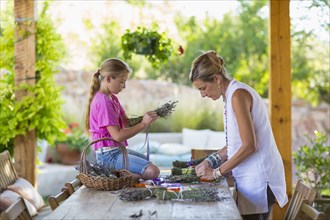 Caucasian mother and daughter making dried flower bundles