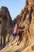 Caucasian girl climbing rock formations