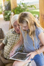 Caucasian grandfather and granddaughter using digital tablet