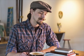 Caucasian man reading in cafe