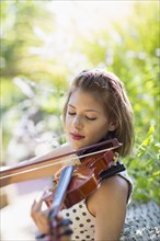 Mixed race musician playing violin outdoors