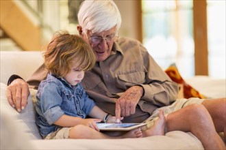 Caucasian grandfather and grandson using digital tablet