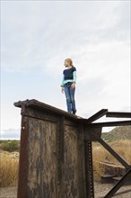 Caucasian girl climbing rusty structure outdoors