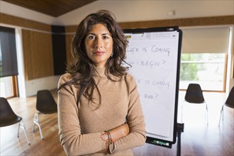 Hispanic businesswoman standing in meeting room