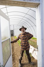Caucasian farmer opening greenhouse door