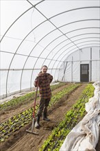 Caucasian farmer standing in greenhouse