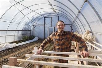 Caucasian farmer standing in greenhouse