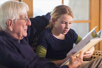 Caucasian grandfather and granddaughter reading