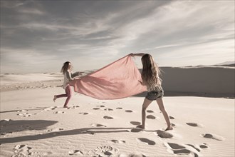 Caucasian children playing in desert