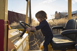 Caucasian preschooler boy driving tractor