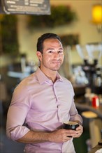 Hispanic businessman drinking coffee in coffee shop