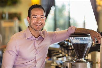 Hispanic businessman smiling in coffee shop