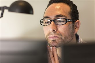 Hispanic businessman using computer in office