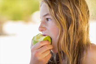 Caucasian girl eating green apple