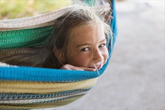 Smiling Caucasian girl laying in hammock