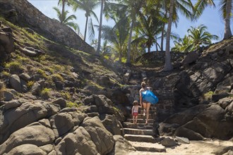 Caucasian mother and son climbing staircase on beach