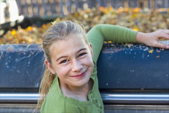 Caucasian girl smiling near autumn leaves in truck