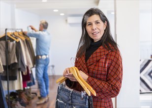 Woman shopping for jeans in clothing store