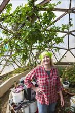 Caucasian woman gardening in greenhouse